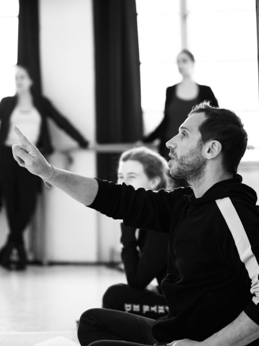 Yorgos Karamalegos speaking to an actor in the studio, one arm outstretched.