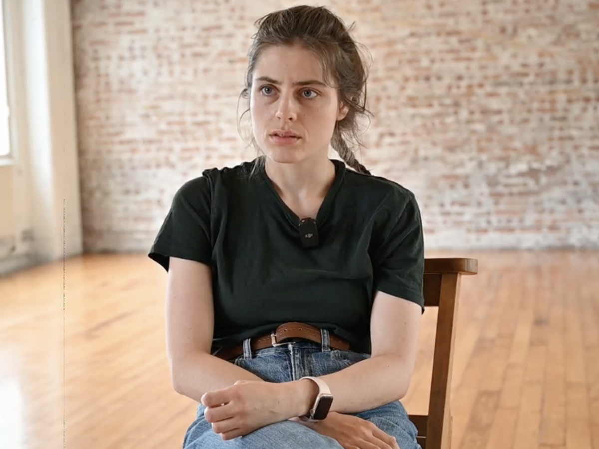 Young woman with dark hair sitting down to film audition tape