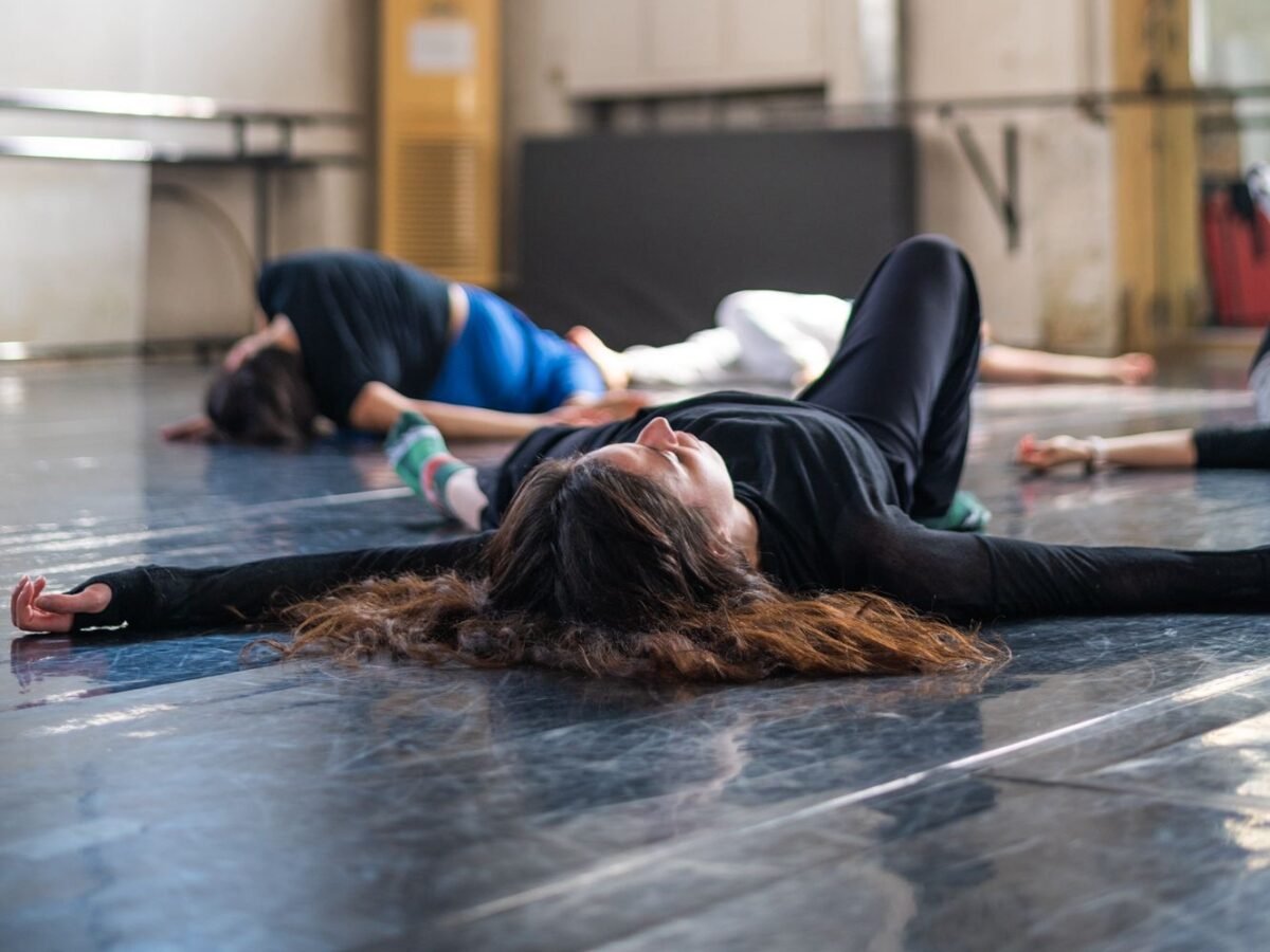 Woman with brown hair laying on the floor of a studio